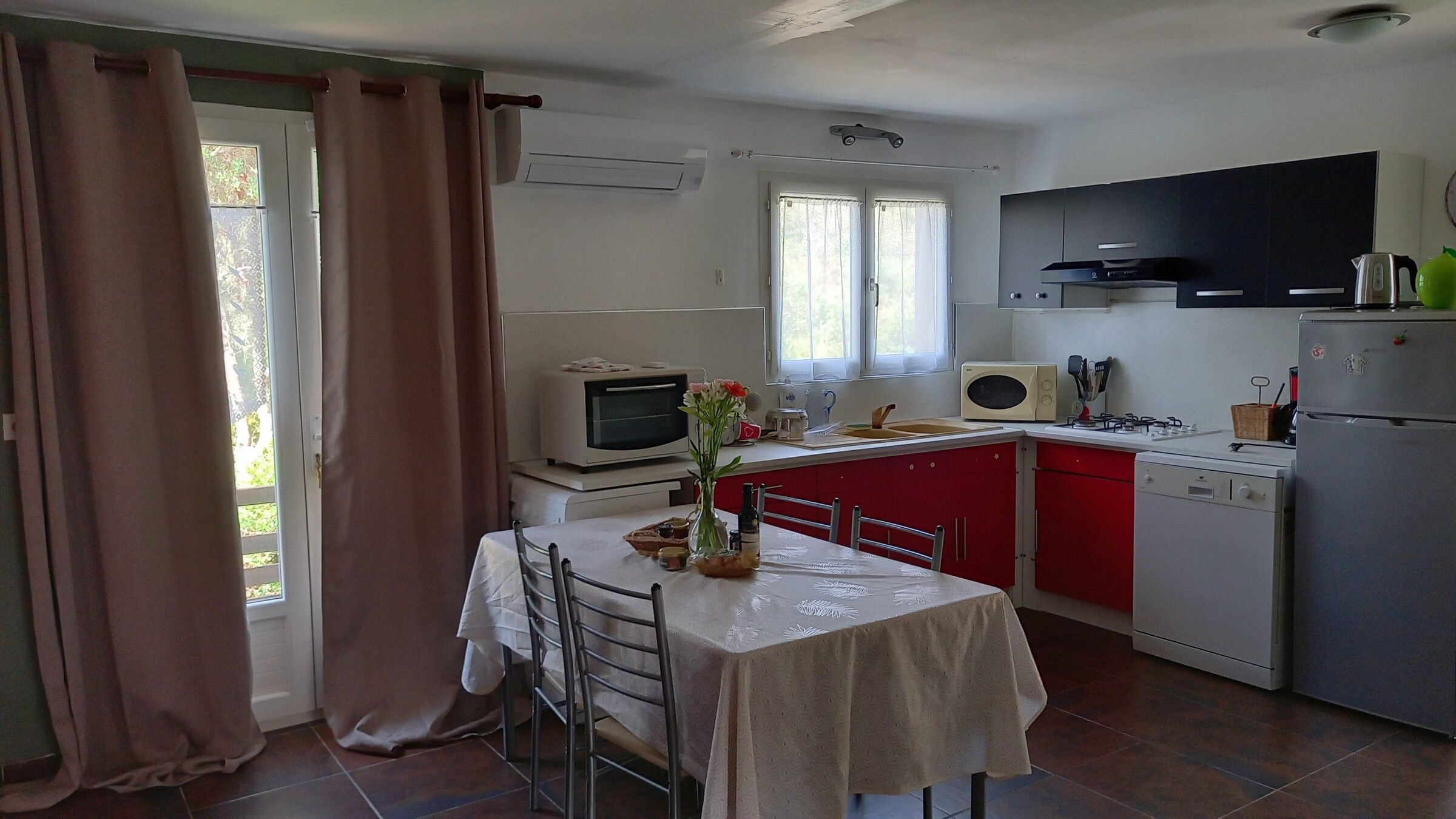 La cuisine équipée, ouverte sur la pièce à vivre et éclairée par deux fenêtres