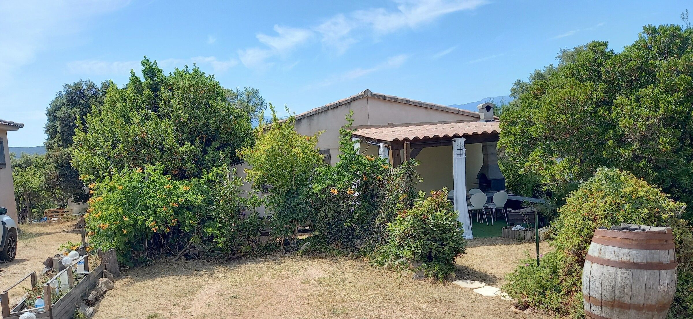 La maison vue depuis le jardin, entourée de végétation méditerranéenne