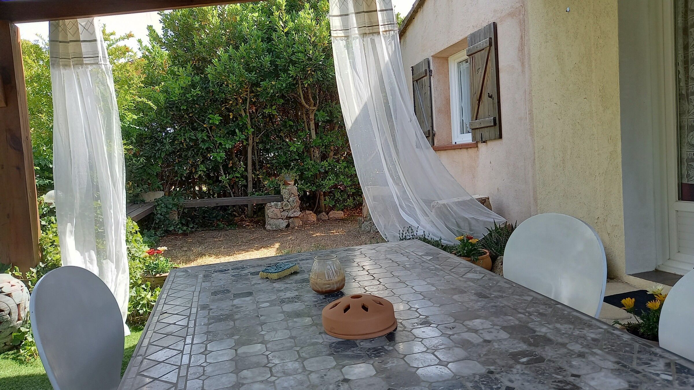 Le plateau de pierre de la table de la terrasse, vu de près, jardin en arrière-plan