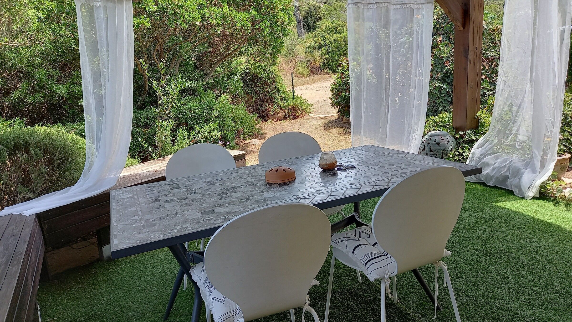 La grande table de la terrasse, dressée face au jardin et au maquis